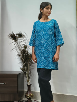 Model wearing teal blue geometric print cotton short kurti with wide sleeves indoors