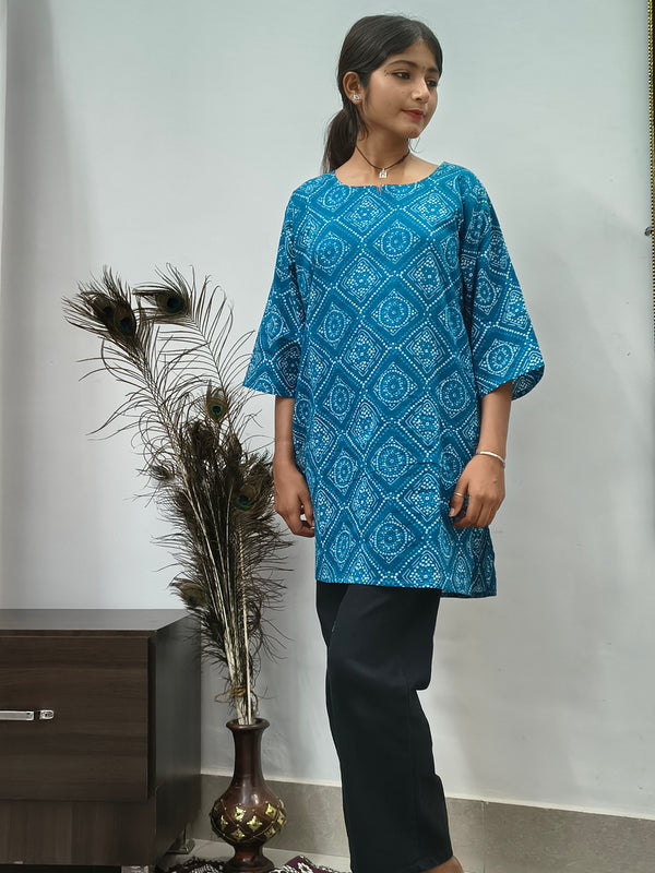 Model wearing turquoise blue geometric print short cotton kurti with wide sleeves indoors