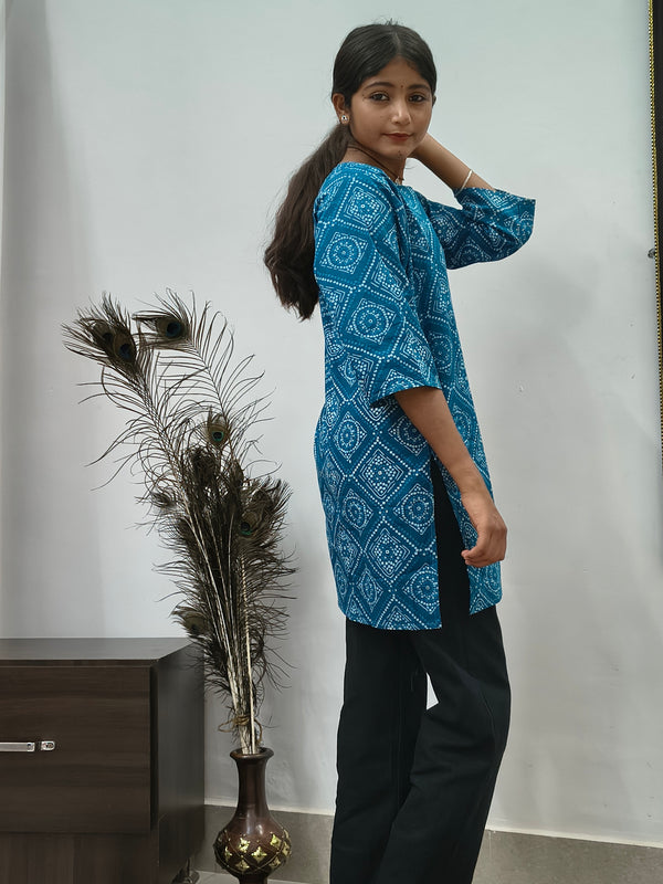 Model wearing teal blue geometric print cotton short kurti with wide sleeves indoors