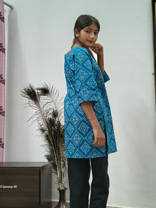 Model wearing turquoise blue geometric print short cotton kurti with wide sleeves indoors